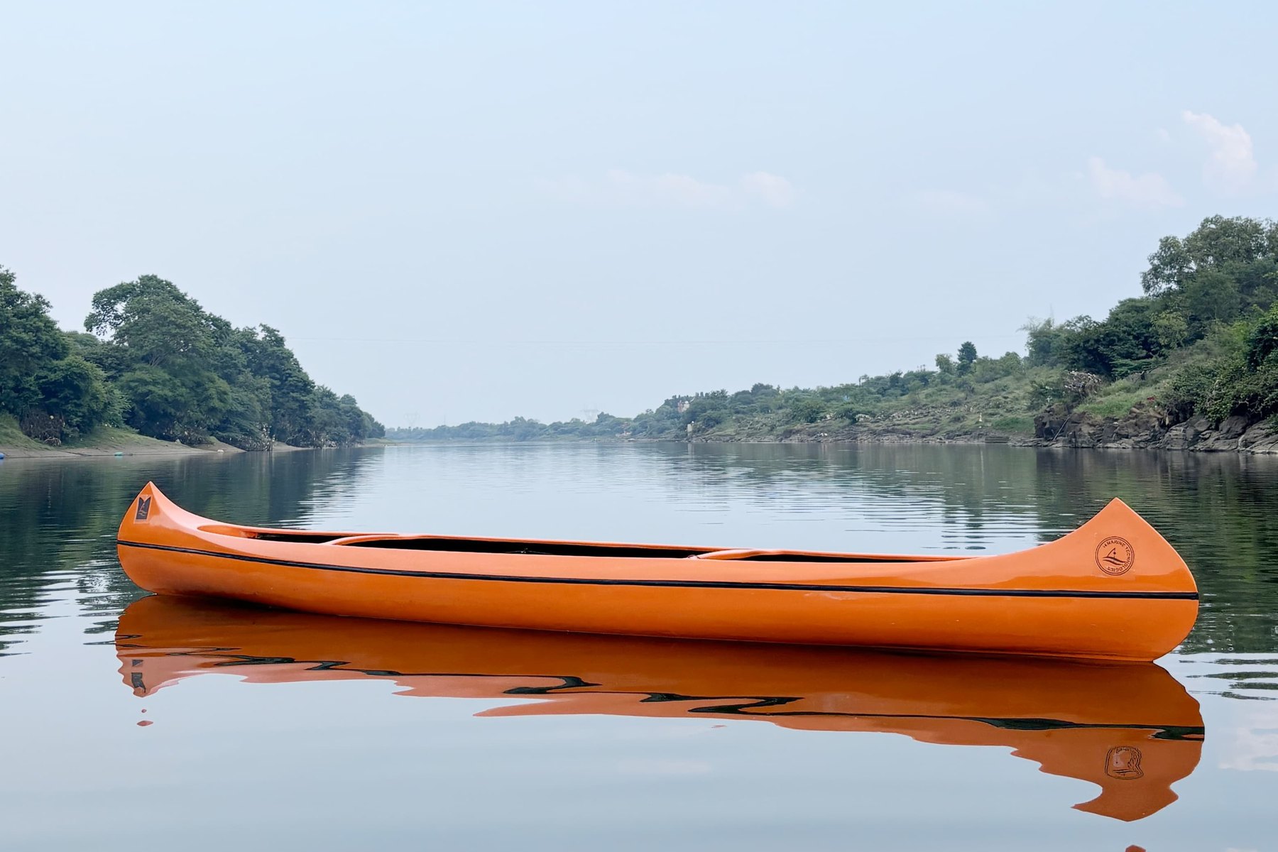 Aqua-Canoe fibreglass electric canoe at rest on a calm river